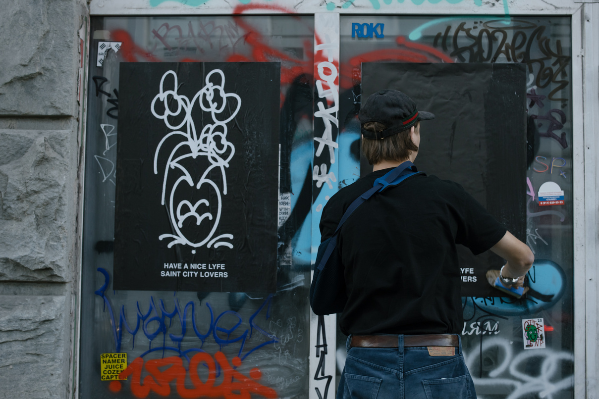 Back View Shot of a Person in Black Shirt Vandalizing on a Glass Wall